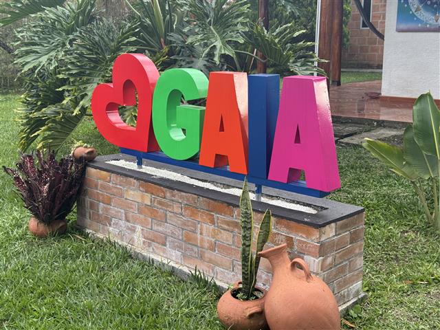 eco-hotel-gaia-7 - Turismo en el Eje Cafetero, Alquiler de Fincas en el Quindio Colorful 3D letters spelling 'GAGA' (red heart-shaped first letter) on a brick planter in a garden.